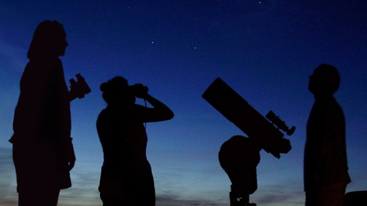 silhouettes of people looking at space  