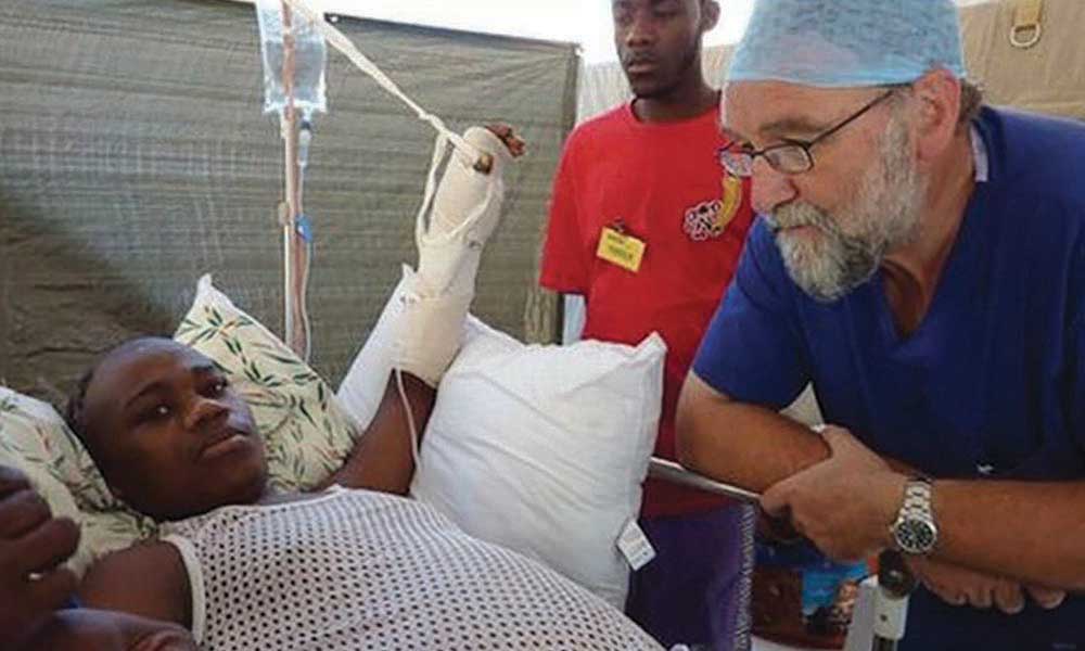 Professor Tony Redmond OBE treating patients after an earthquake