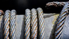 Black ropes tied around canal crane equipment.